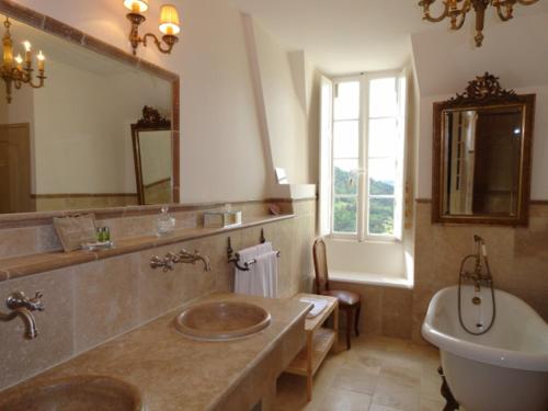 een badkamer met een wastafel, een bad en een toilet bij Chateau d'Urbilhac in Lamastre