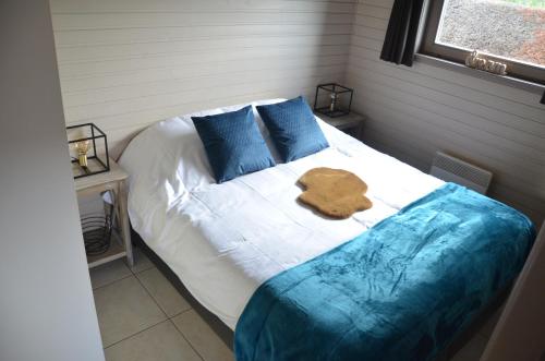a bedroom with a bed with blue pillows at Vakantiehuis Gertrude in Middelkerke