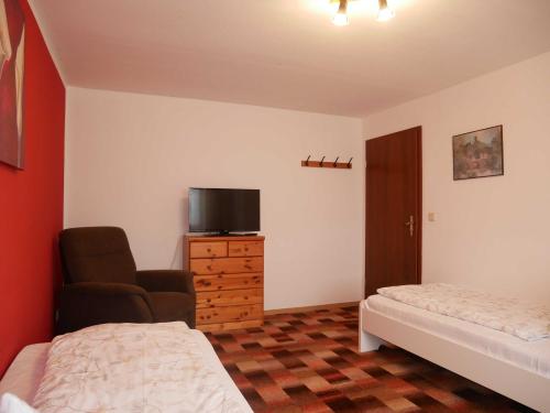 a bedroom with a bed and a chair and a television at Ferienwohnung Mecklenburgische Seenplatte in Schwichtenberg