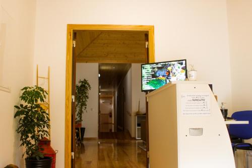 a room with a refridgerator with a television on top of it at Casa de Campo Vale do Ceira in Góis