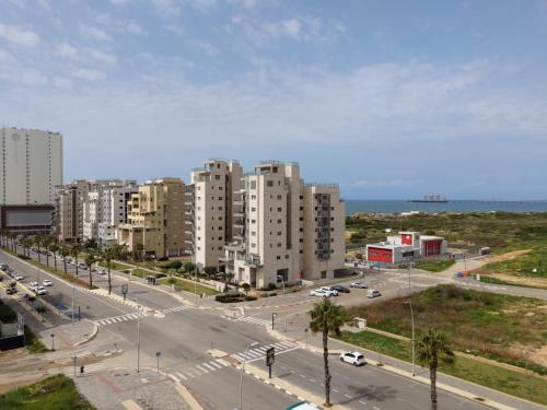 a city with tall buildings and a street with cars at SEA& SUN in H̱adera