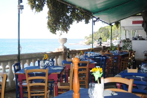 un restaurante con mesas y sillas azules y el océano en Villa Tergeste en Trieste