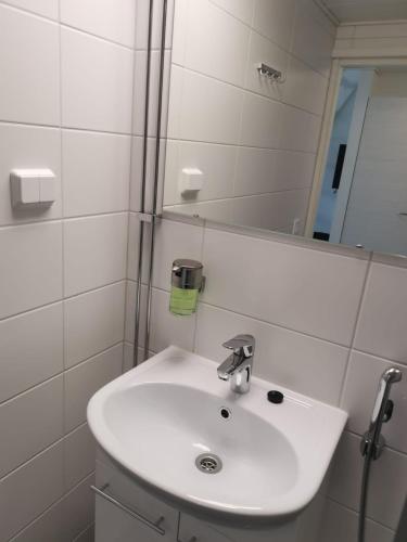 a bathroom with a white sink and a mirror at Innotelli Apartments in Helsinki