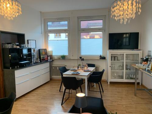 a kitchen with a table and chairs in a room at Hotel Prinz Carl - Apartments mit Klimaanlage in Neckarsulm