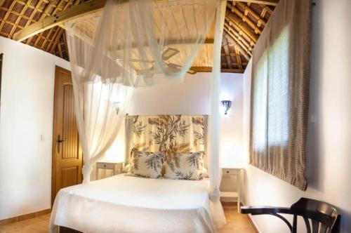 a bedroom with a white bed with a canopy at Finca el Abuelo Manuel in Vejer de la Frontera