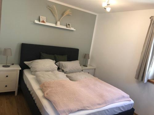 ein Bett mit einer Decke darauf in einem Schlafzimmer in der Unterkunft Fewo Glücksfall in Berchtesgaden