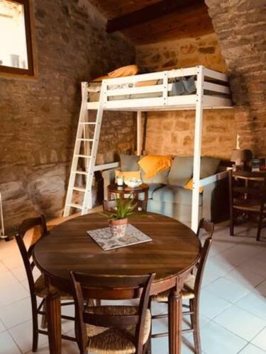 a dining room with a table and a bunk bed at Petite Maison pleine nature in La Bastide-Pradines