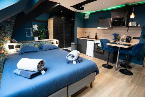 une chambre avec un grand lit et une cuisine dans l'établissement Capsule color deluxe Balnéo I écran home cinéma I console de jeux, à Trith-Saint-Léger