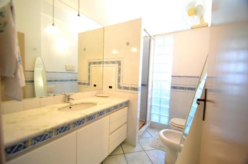 スコペッロにあるVilla Orlando Scopelloのバスルーム(洗面台、トイレ、鏡付)