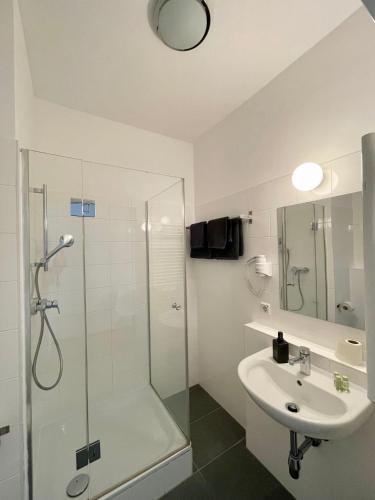 a white bathroom with a shower and a sink at Dan In'n Out in Vienna