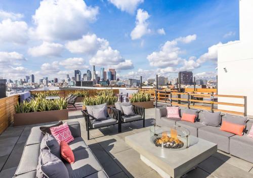 a rooftop patio with furniture and a view of the city at Apart Hotel near Dodgers Stadium in Los Angeles
