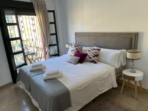 a bedroom with a large white bed with pillows at Amador Apartamento Familiar Centro PARKING Amador de los Rios in Seville