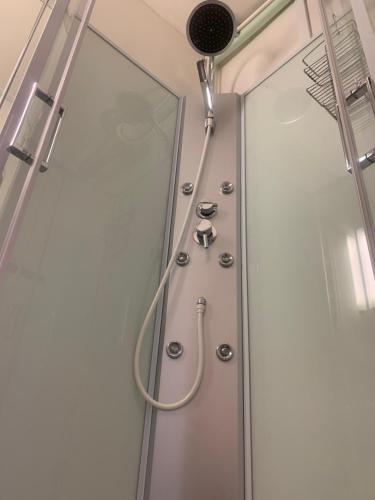 a shower with a hose hanging from the ceiling at Bungalow house flat in Rekola 33m2 in Vantaa