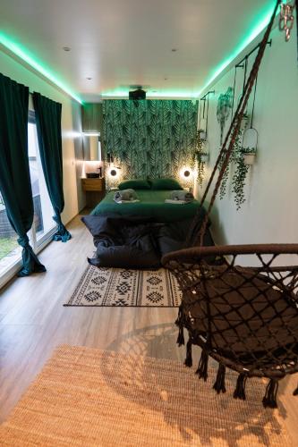 a bedroom with a bed and a hammock in a room at Capsule Thailande I Sauna I Balnéo I Console I jeux en bois I Cinéma I cour intérieure in Trith-Saint-Léger