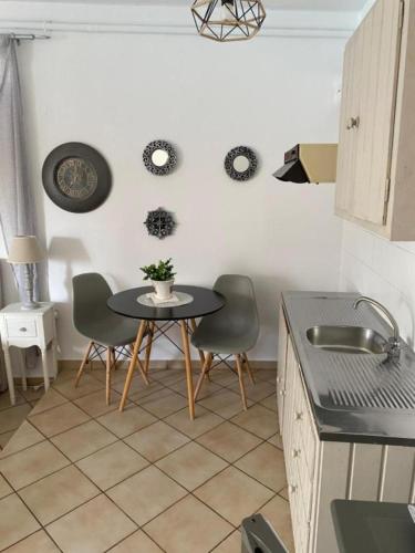 a kitchen with a table and chairs in a kitchen at Kasteli Studios & Apartments in Panormos Rethymno