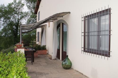 a white house with an awning and a patio at Il Pino Bioagricoltura in Terranuova Bracciolini