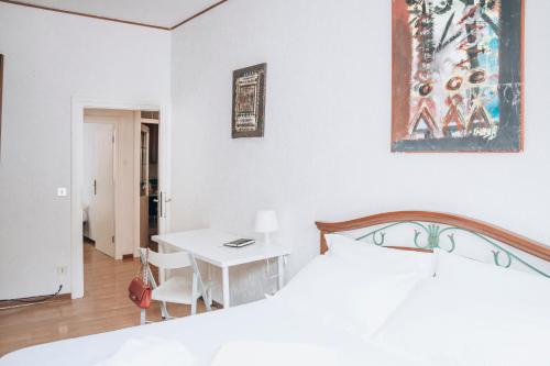 a white bedroom with a bed and a table at Bricola Biennale Apartments in Venice