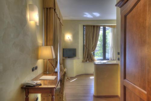 a room with a hallway with a desk and a window at Central Park Hotel Modena in Modena