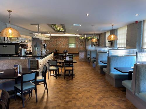 un ristorante con tavoli e sedie e un bar di The Grange Manor a Grangemouth