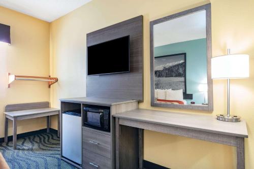 a hotel room with a television and a desk with a microwave at Super 8 by Wyndham Kokomo in Kokomo