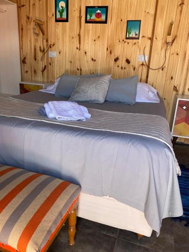 a large bed in a room with wooden walls at Hostal Asqui Pacha in Tilcara