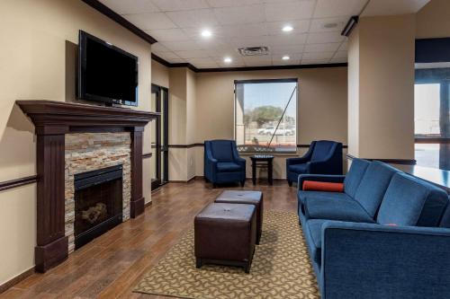 a waiting room with a couch and a fireplace at Comfort Suites Waco Near University Area in Waco
