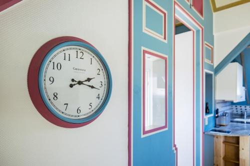 a clock hanging on a wall next to a door at Rooftop Penthouse Karlsruhe in Karlsruhe