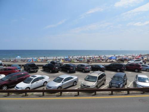un montón de coches estacionados en un estacionamiento cerca de la playa en The Atlantic Motel, en Hampton