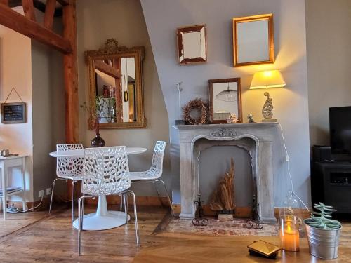 sala de estar con chimenea, mesa y sillas en LE VALENTIN - Parking privé offert - Coeur Historique -La Clef de Honfleur en Honfleur