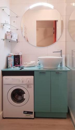 La salle de bains est pourvue d'un lave-linge et d'un miroir. dans l'établissement 2 Piéces Clim Face a la plage vue Mer, à Cavalaire-sur-Mer