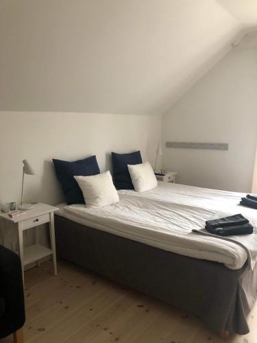 a bedroom with a large bed with blue pillows at Hotell Villa Rönne in Ängelholm