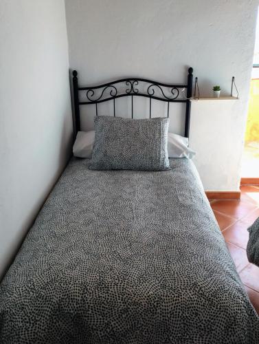 a bed with a black headboard in a room at El Rinconcito de Nadia in Benaocaz