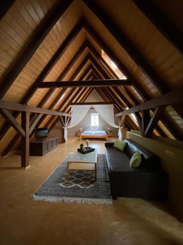 a living room with a black couch in a attic at Gasthaus Holdermühle in Creglingen