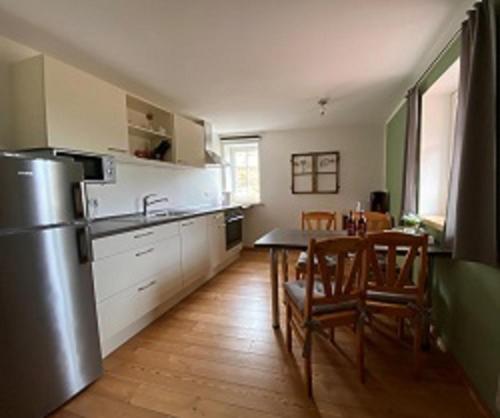 a kitchen with a table and chairs and a refrigerator at Gasthaus Holdermühle in Creglingen
