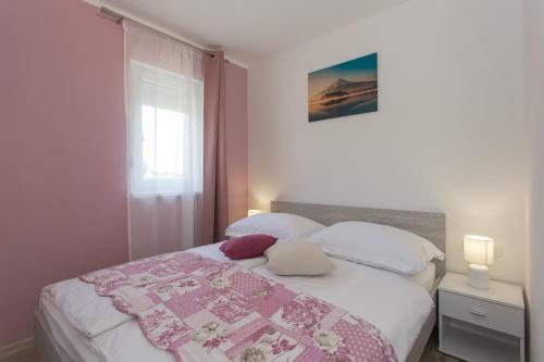 ein Schlafzimmer mit einem Bett mit einer Decke darauf in der Unterkunft VILLA HONEY, Seget - Trogir in Seget Vranjica