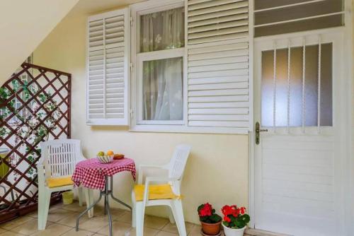 um alpendre com uma mesa e cadeiras e uma porta em Dubrovnik: Apartment Quiet Corner em Dubrovnik