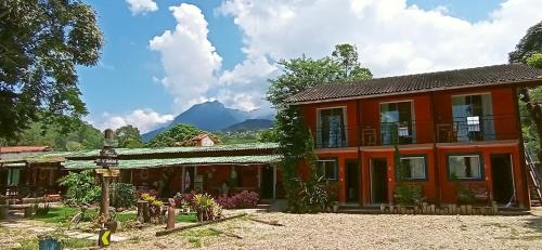 an orange house with mountains in the background at Casa Dos Artistas in Penedo