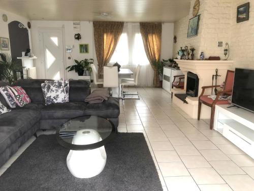 a living room with a couch and a table at Villa de 4 chambres avec piscine privee jardin clos et wifi a Saint Martin Longueau in Saint-Martin-Longueau