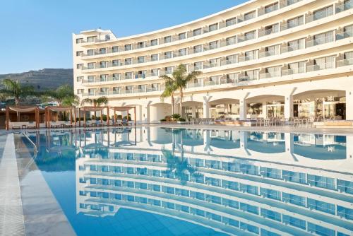 un hôtel avec une piscine en face d'un bâtiment dans l'établissement Lindos Bay Hotel, à vlicha