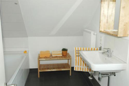 a bathroom with a sink and a shelf with towels at Ole & Trude in Kiel