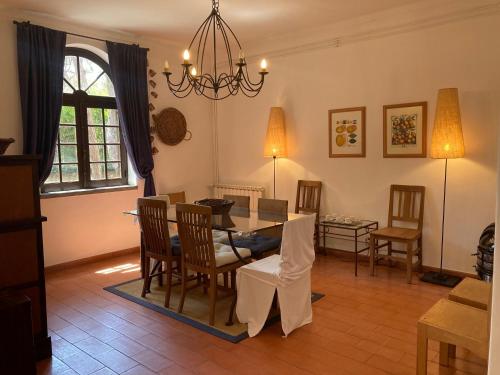 a living room with a dining room table and chairs at Moradia no Pinhal com Piscina - Espaço e Privacidade para as suas Férias! in Sintra