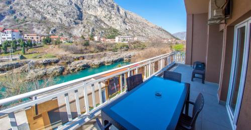 a balcony with a table and chairs and a mountain at Mila Apartments in Mostar