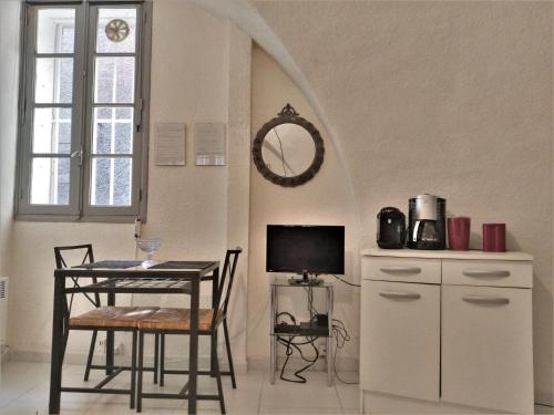 uma sala de jantar com uma mesa e uma mesa e uma televisão em "Sous les Voûtes" -Garage privé optionnel -Centre historique-Plages à 21km ! em Pézenas