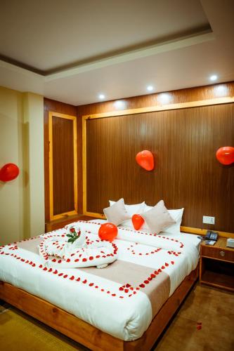a bedroom with a large bed with red decorations on it at Paradise Boutique Hotel in Pokhara