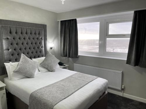 a bedroom with a large bed and a window at Park House Hotel in Blackpool