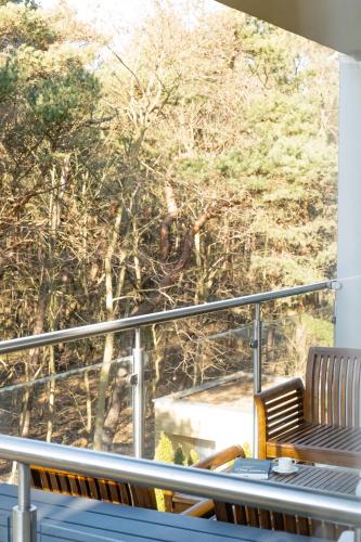 a balcony with a table and a view of a bridge at Dariusz Apartament PREMIUM Jurata z garażem in Jurata