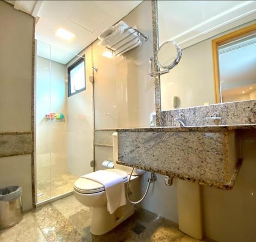 a bathroom with a sink and a toilet and a shower at RARIDADE!!! - Flat de Alto Padrão - Excelente Atendimento - Ótimo Preço - Cama King Size - Limpeza Diária Gratuita in Brasilia