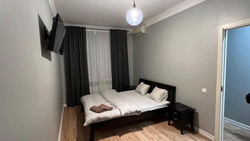 a small bedroom with a bed and a flat screen tv at ApartHotel Riga in Riga