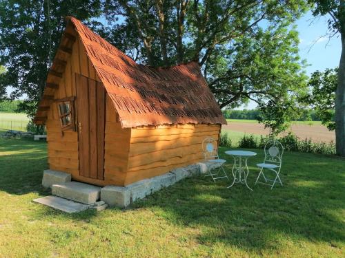 a small wooden cabin with a table and chairs at La Gare de Lurey Conflans gîte et hébergements insolites en Champagne in Esclavolles-Lurey