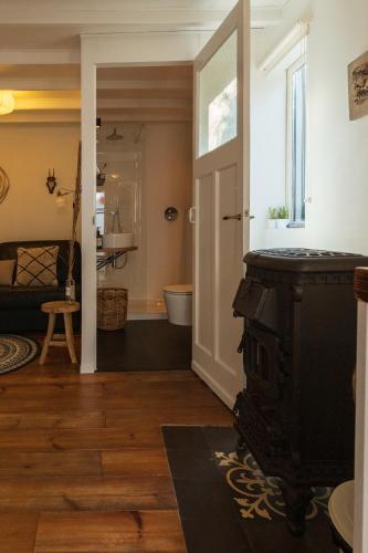 a living room with a fireplace and a bathroom at Authentiek vakantiehuisje in Terneuzen